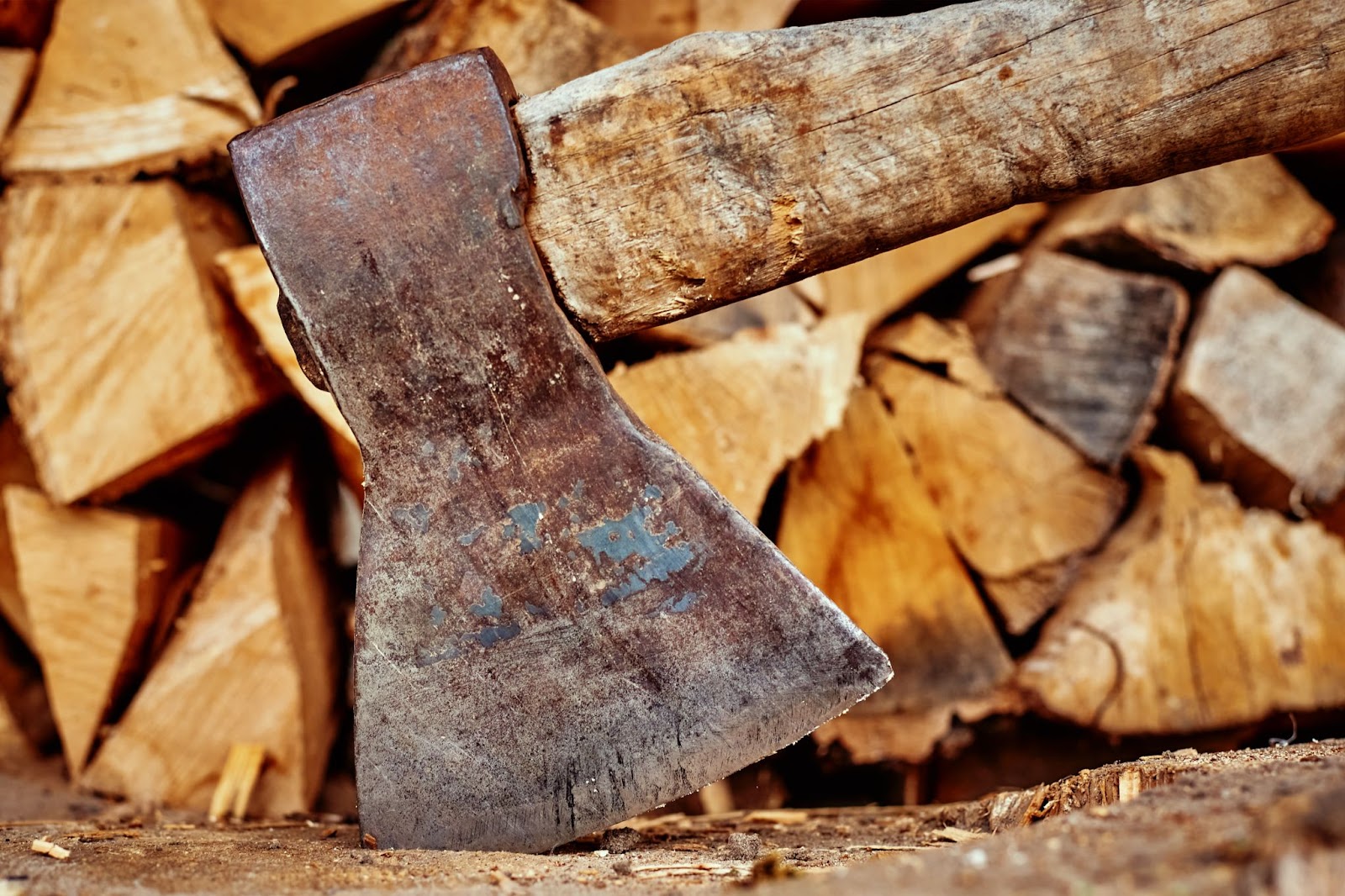 Axe with pieces of cut wood in the background. 