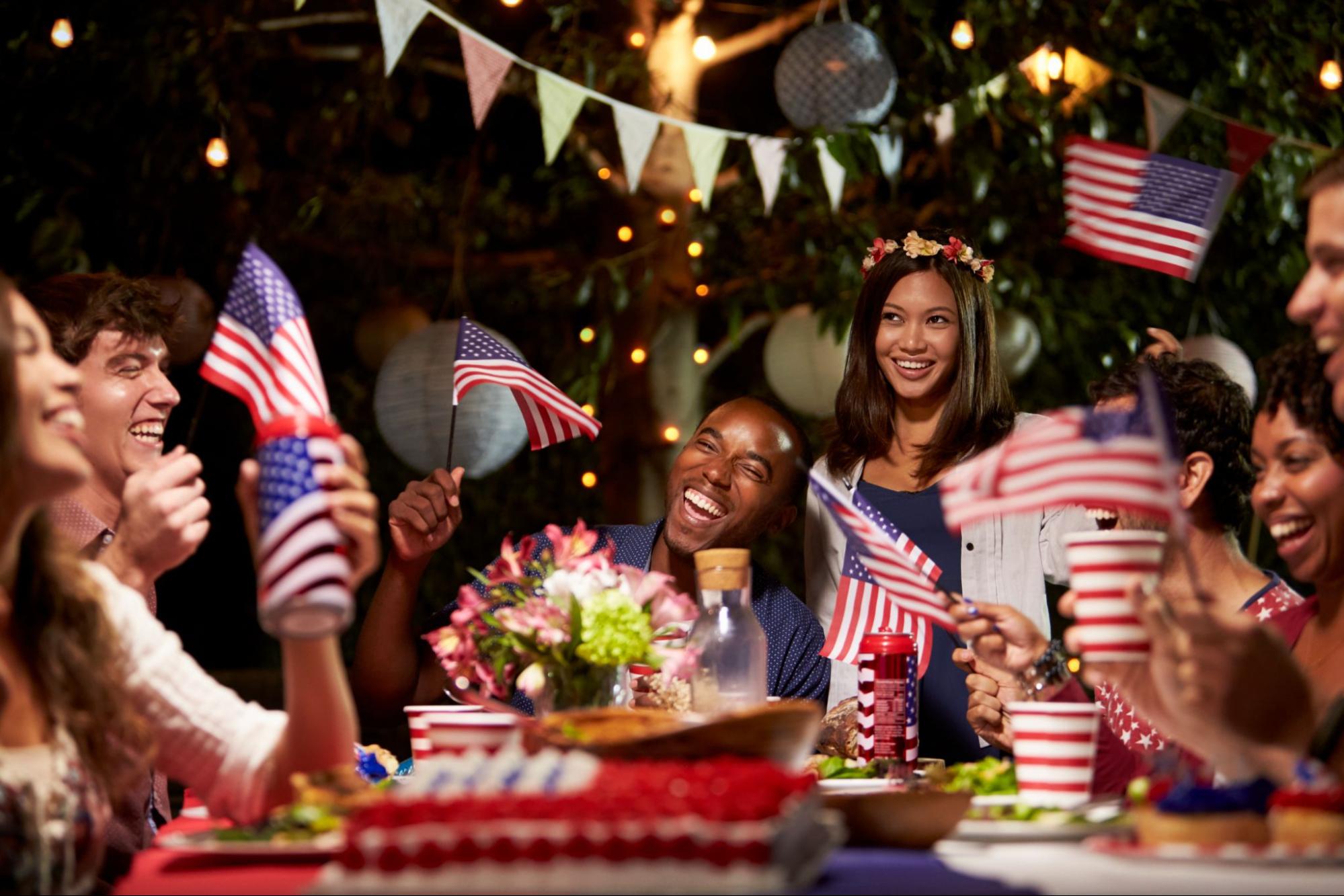 Friends celebrating the Fourth of July in a backyard with flags and some food. [IMAGE] 