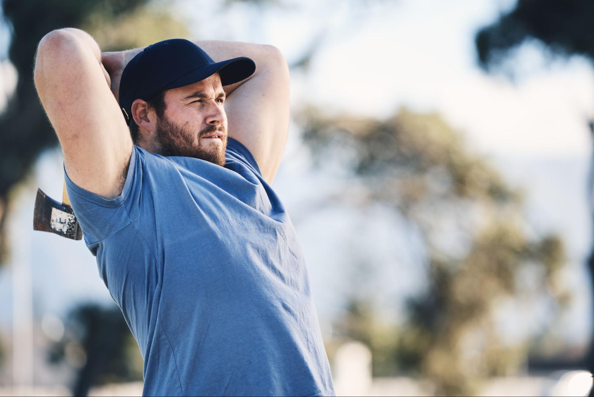 A man throws an axe at the target range during training.