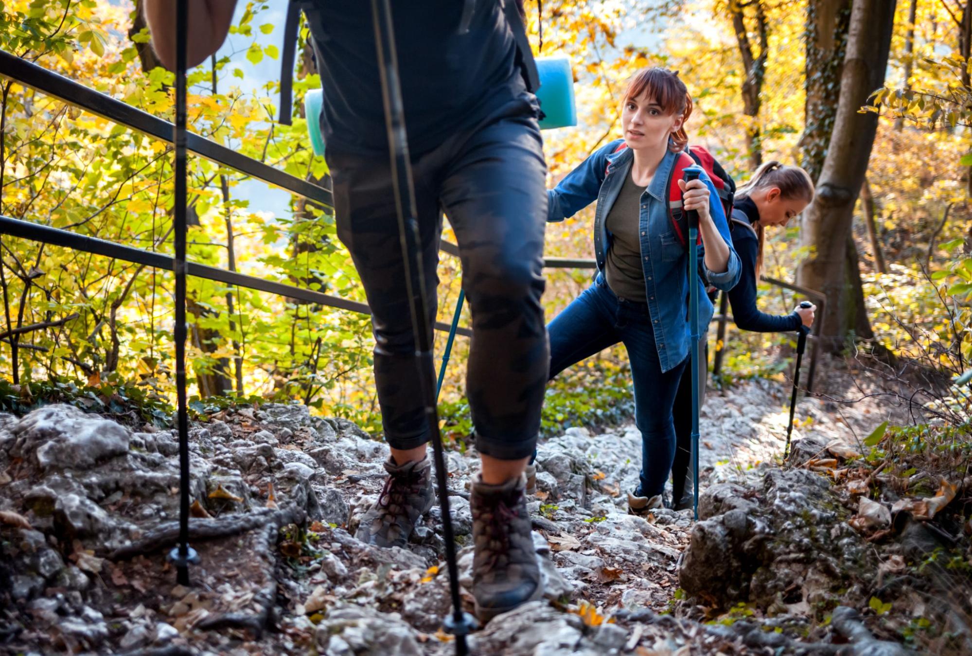 Three people hiking with walking sticks. 