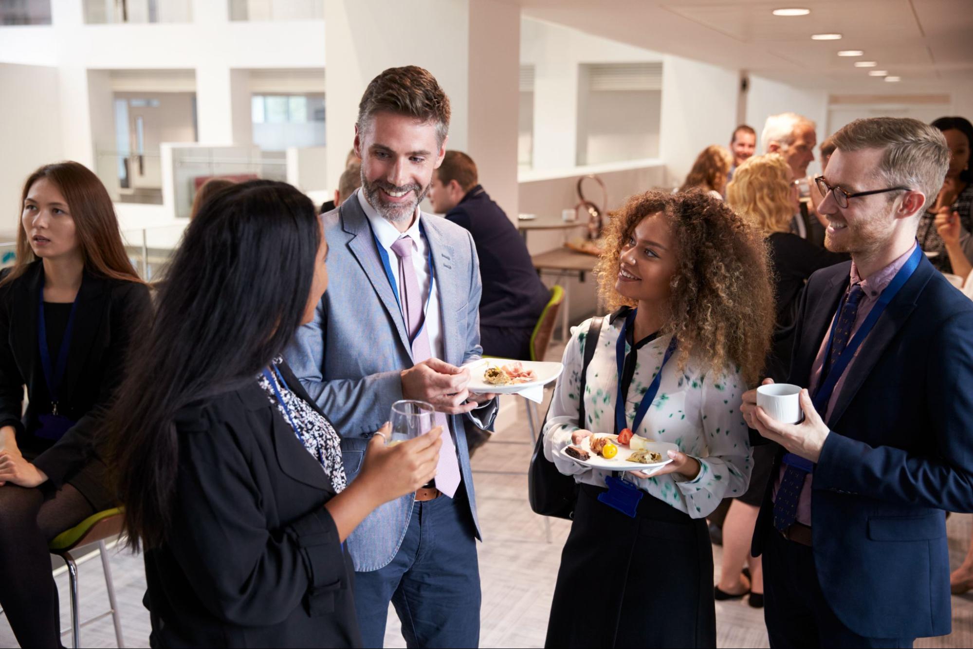 Delegates engage in lively conversation while networking during a conference lunch break. 