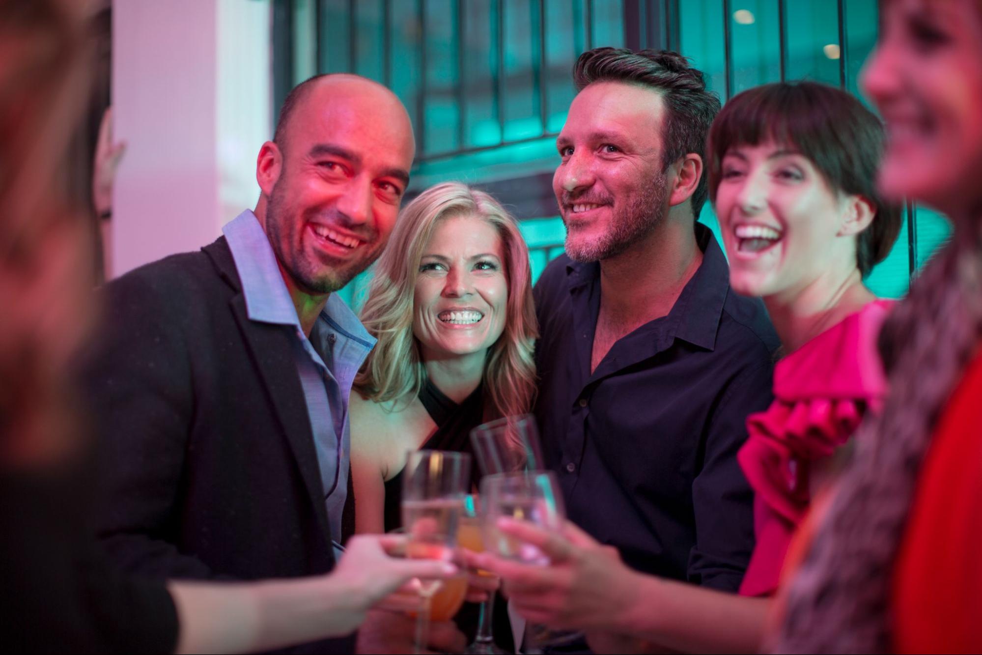 Men and women toasting with champagne glasses. 