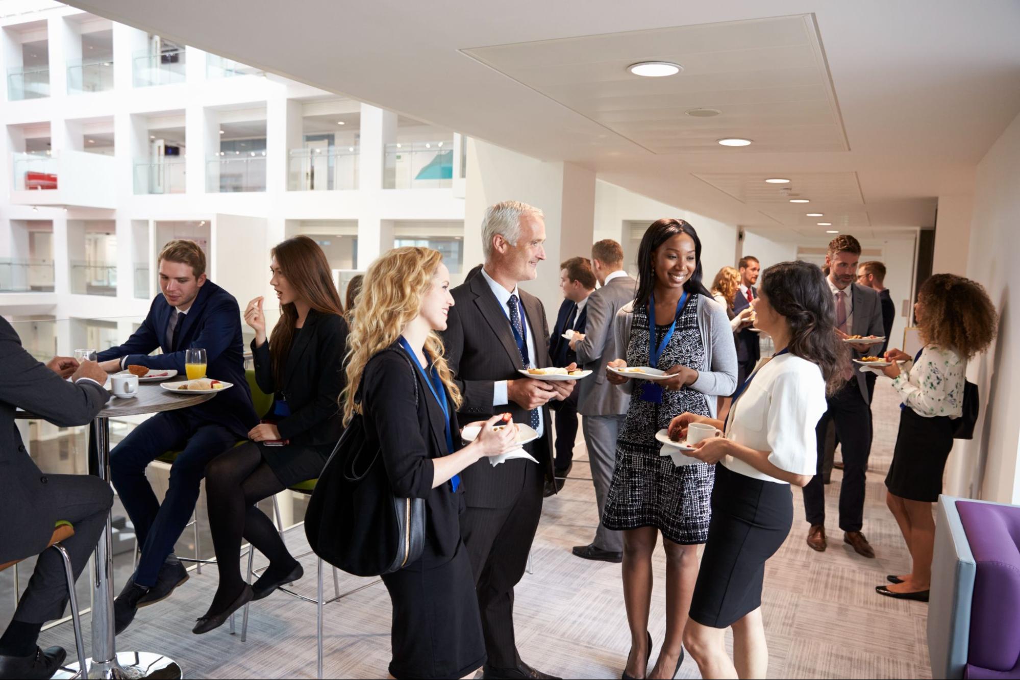 Men and women in formal attire at a corporate event. 