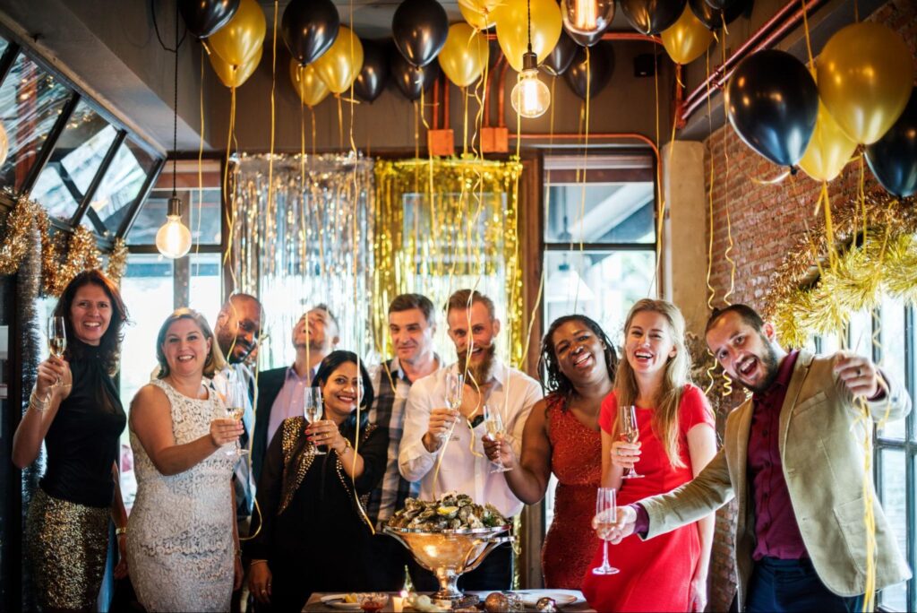 A group of people with glasses and surrounded by balloons.