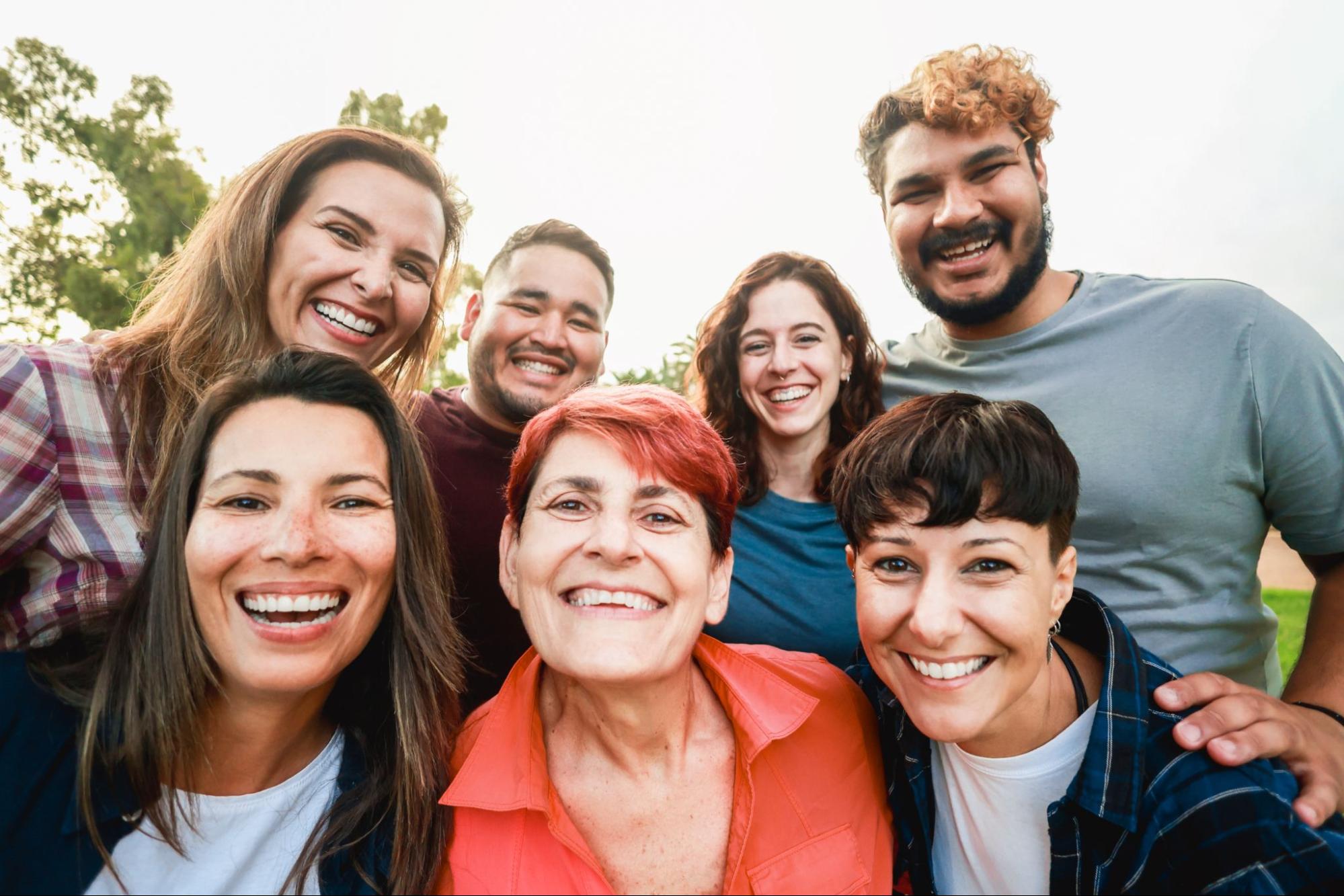 Group of friends huddle together and smiling.