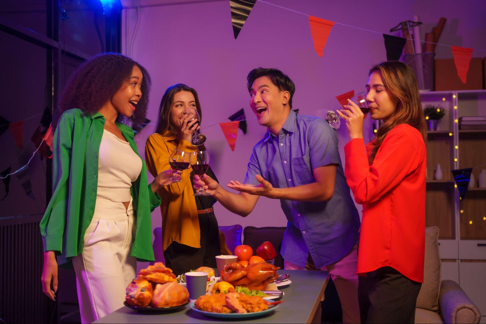 Coworkers celebrating together, smiling and enjoying drinks in a lively, cheerful setting.